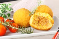 Arancini, rice balls with meat and sauce on complex background
