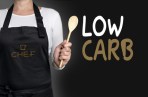 low carb cook holding wooden spoon background concept.